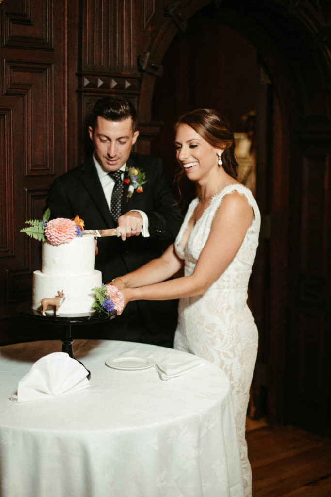 A bride and groom cut their cake at their Branford House Mansion Wedding.