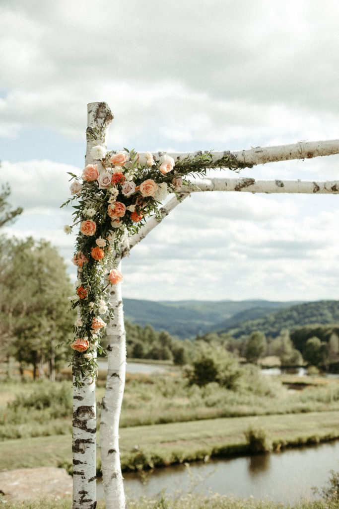 Florals decorating a ceremony arch.