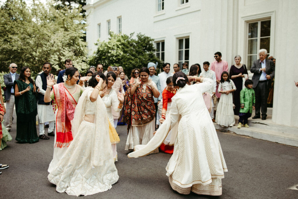 Group of guests dancing energetically to the beat of traditional dhol drums during the Baraat procession.