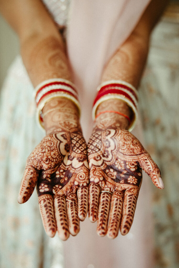 Close-up of intricate henna designs adorning the bride's hands during pre-wedding preparations.