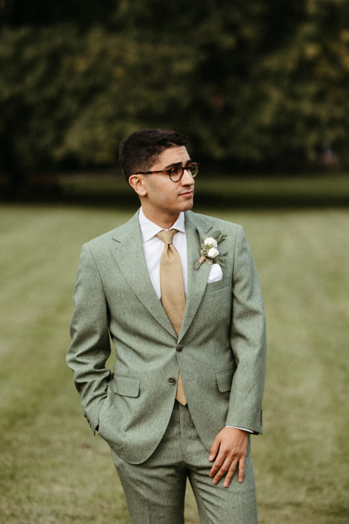 Groom in Green Tweed Suit: Stylish groom in a green tweed suit, setting a non-conventional tone for the Red Maple Vineyard wedding.