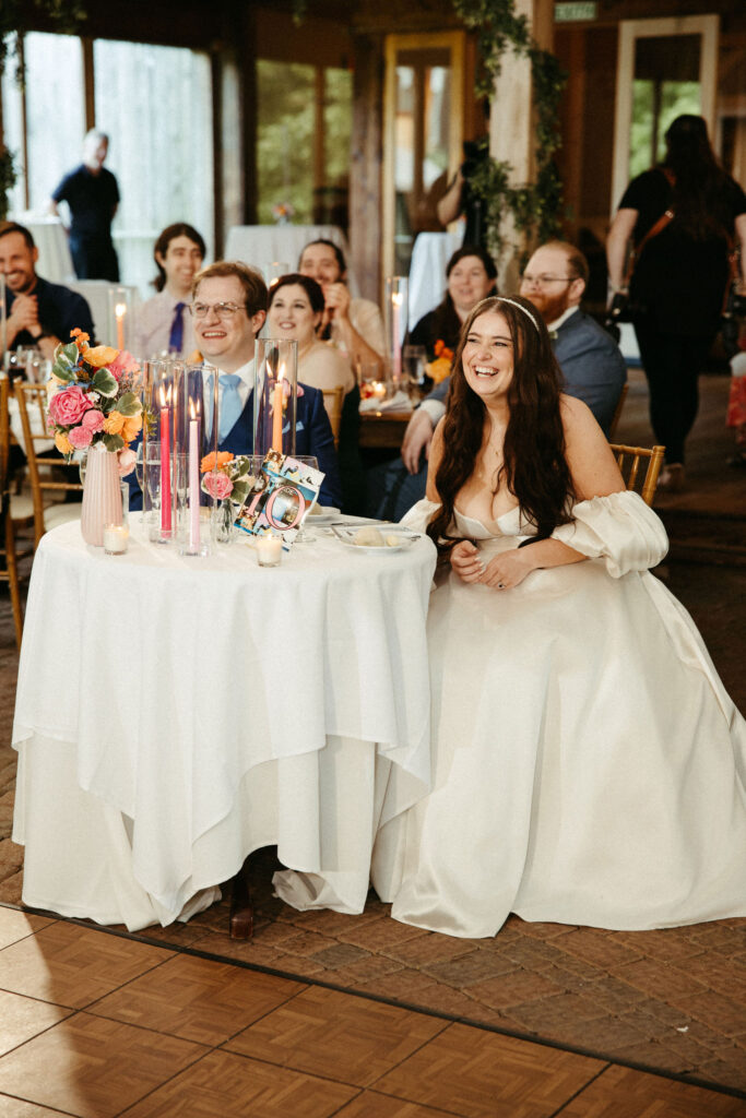 Emotional speech moment as the bride laughs while listening to a toast.