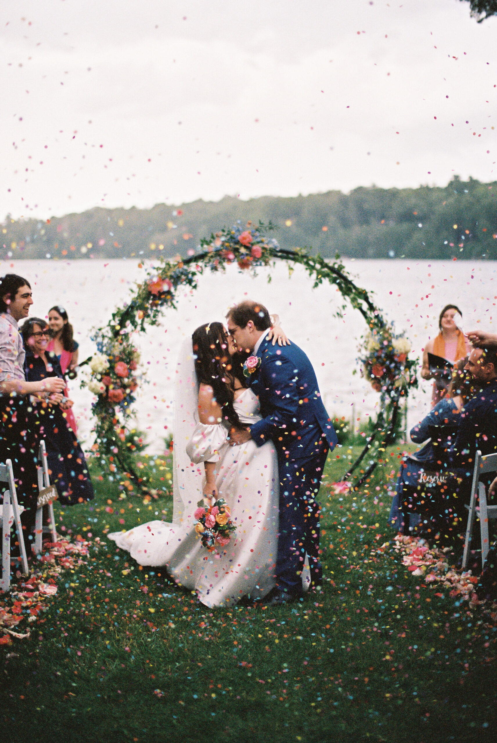 Colorful confetti toss as the newlyweds walk up the aisle, smiling and laughing