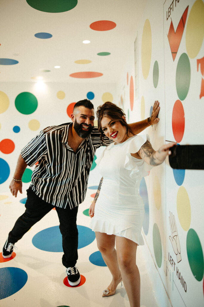 Couple sharing a joyful laugh during their engagement session at the TWA Hotel.