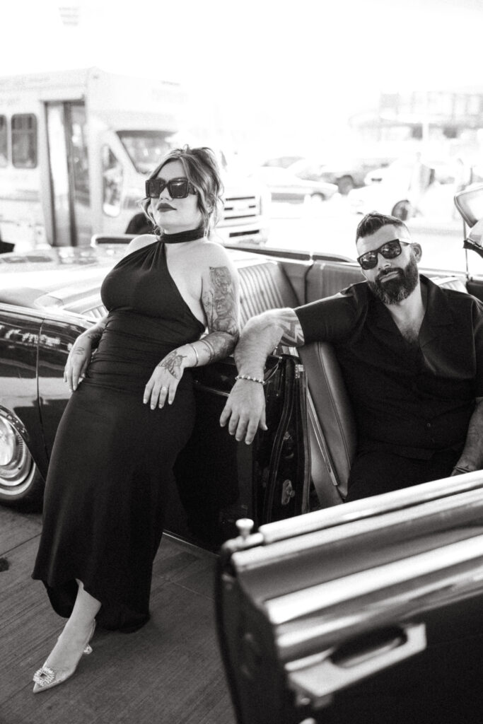 A romantic, retro-inspired engagement shot featuring a classic convertible and the TWA Hotel.h