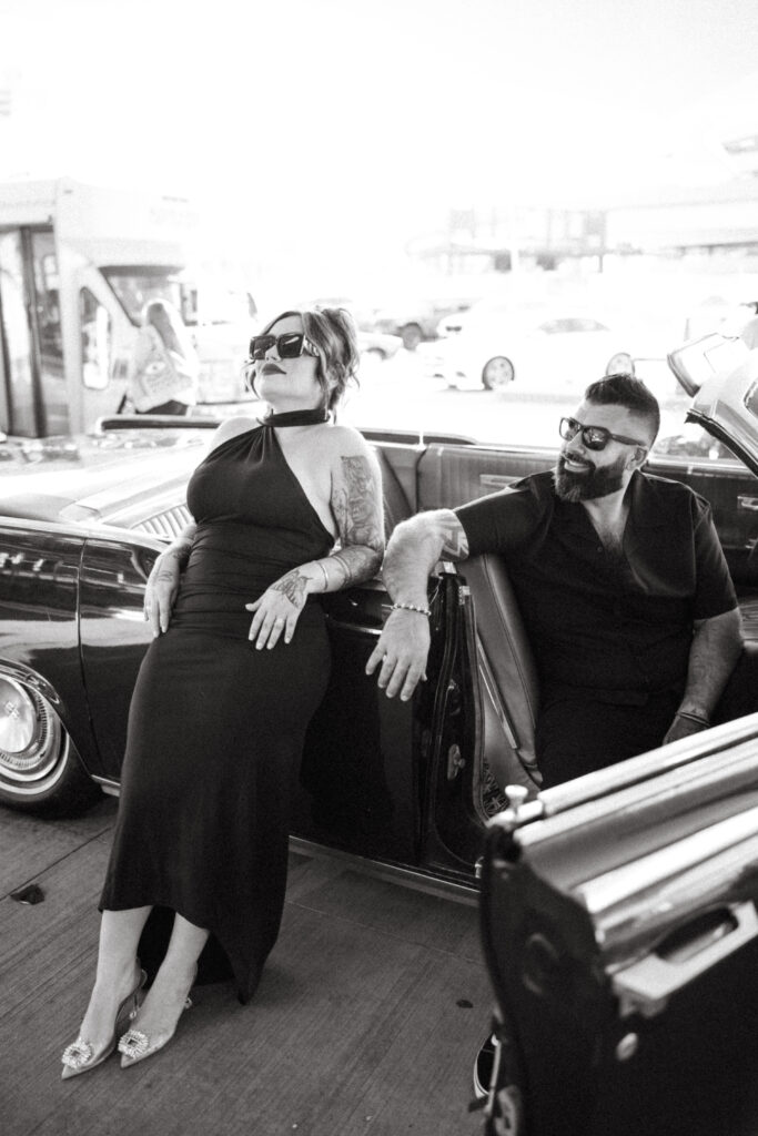 Couple standing beside a classic convertible outside the TWA Hotel, adding a touch of old-school glamour.