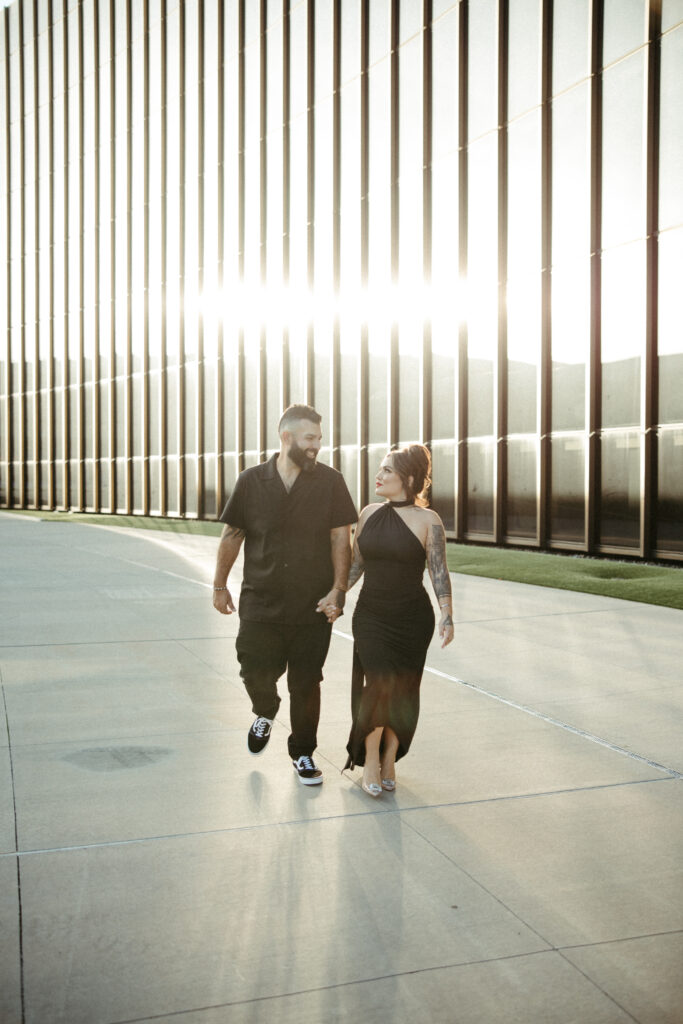 Couple standing in front of the TWA Hotel, framed by its bold, retro-futuristic design.