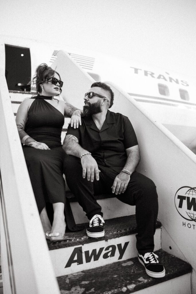 Romantic travel-inspired engagement portraits in front of the historic TWA plane.