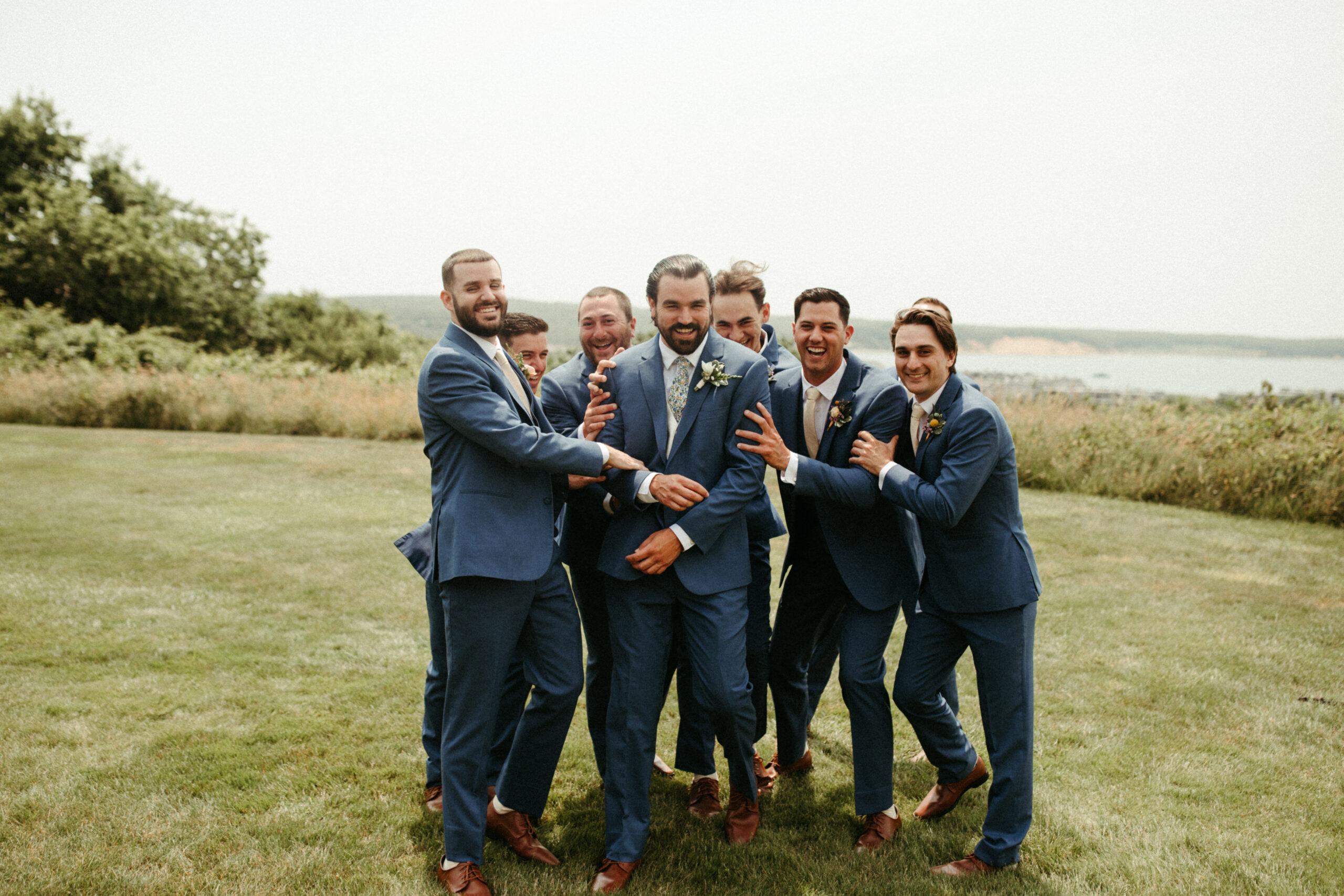 The groomsmen bursts into laughter, celebrating the day with unposed joy.