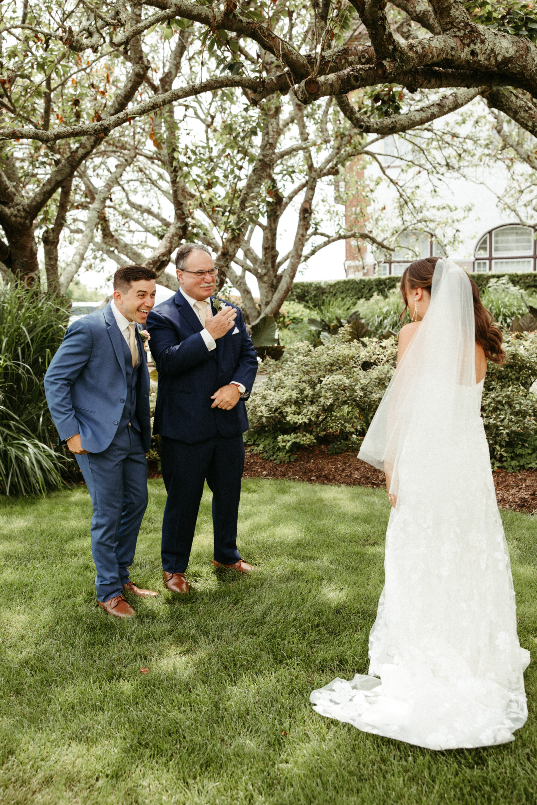 An emotional reaction to the bride's brother and father seeing her for the first time.