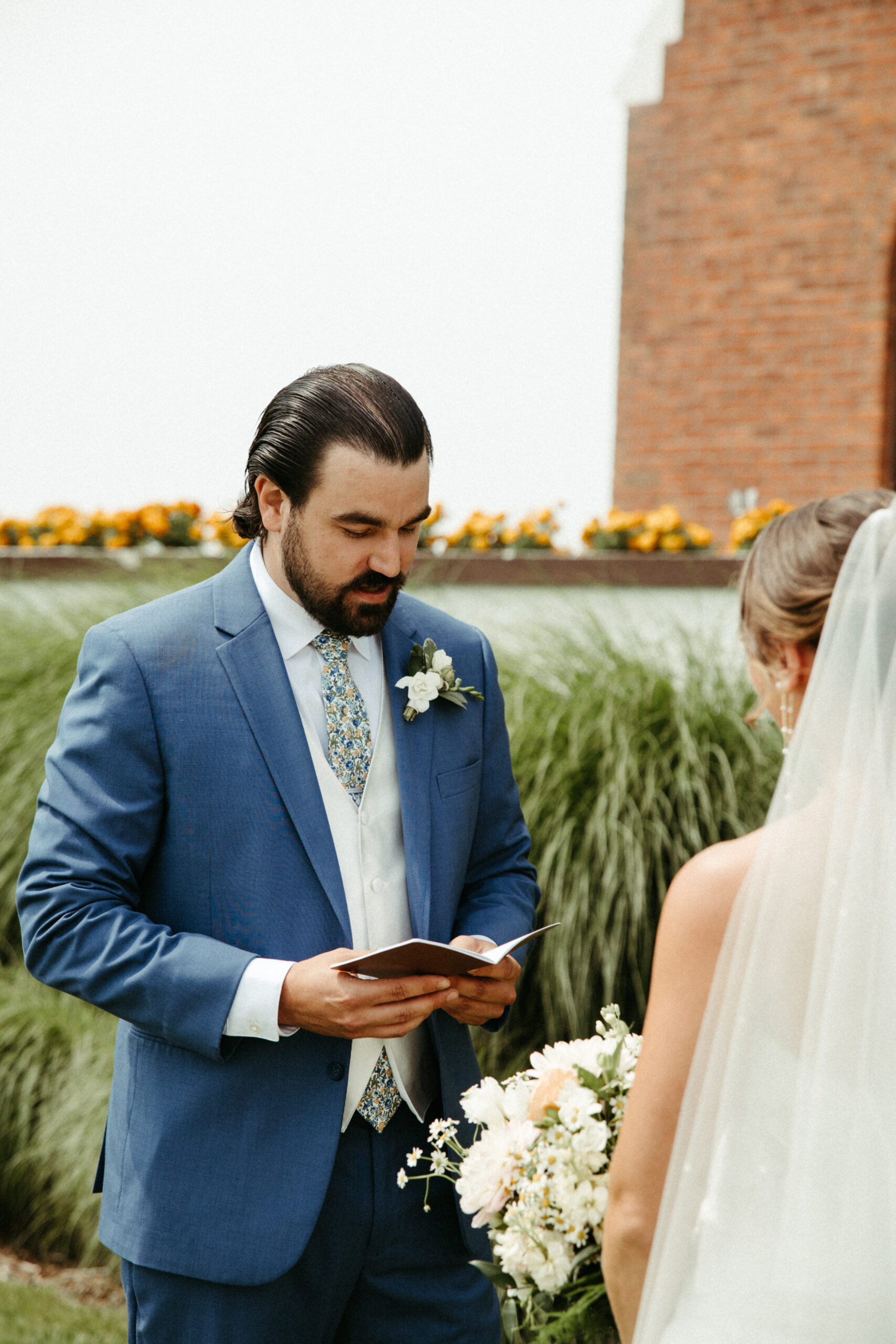 A groom reads his private vows to his bride in front of Montauk manor.