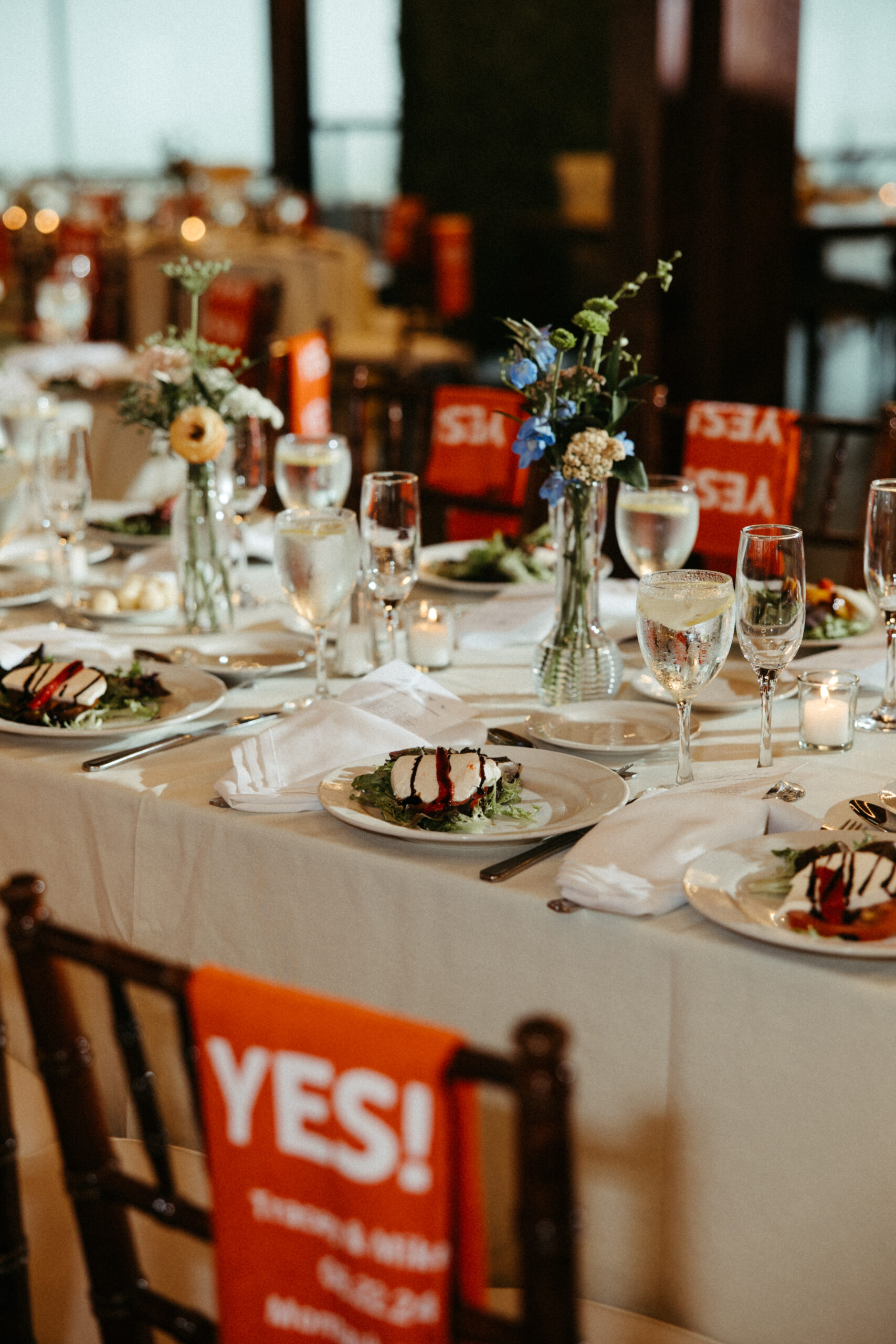  Elegant tables with flickering candlelight and lush floral arrangements fill the venue.