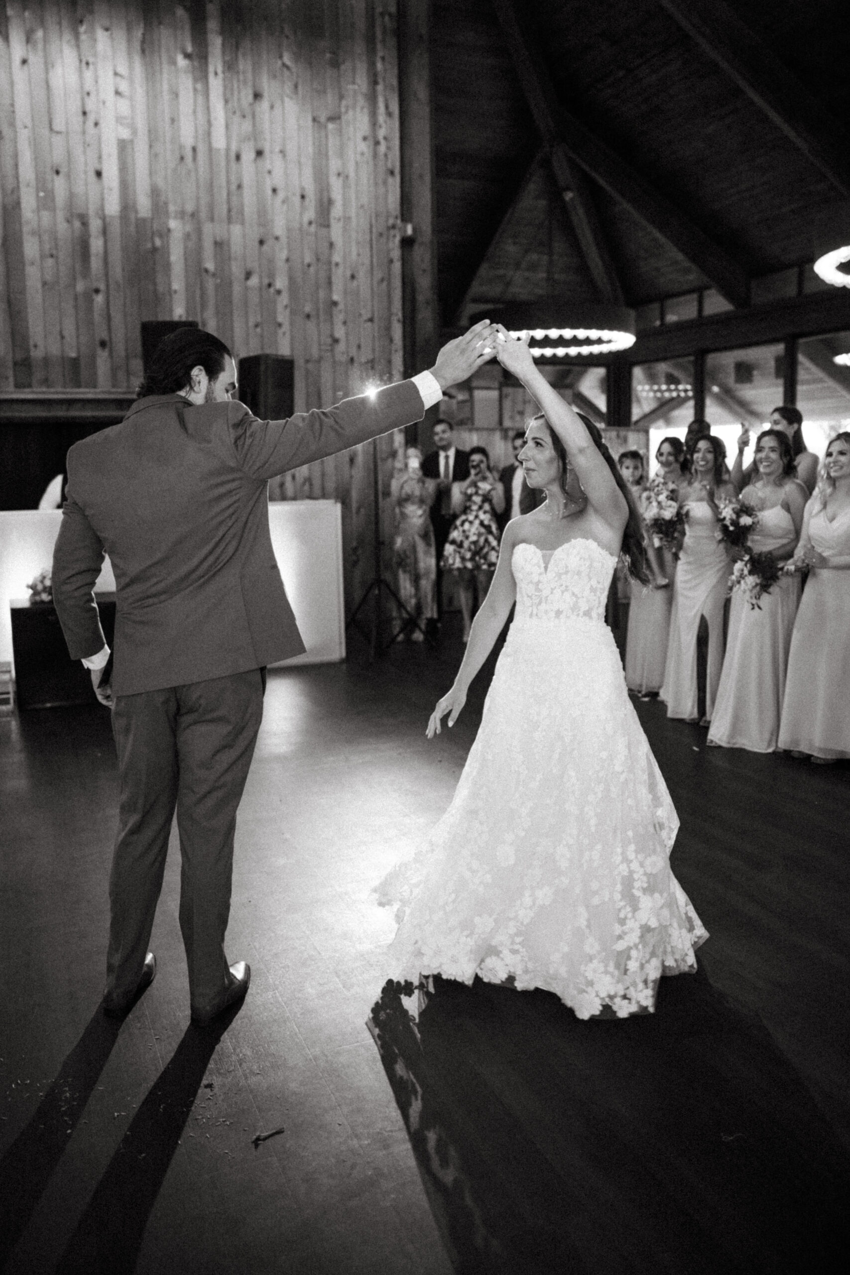 The bride and groom sway together beneath a cascade of twinkling string lights.