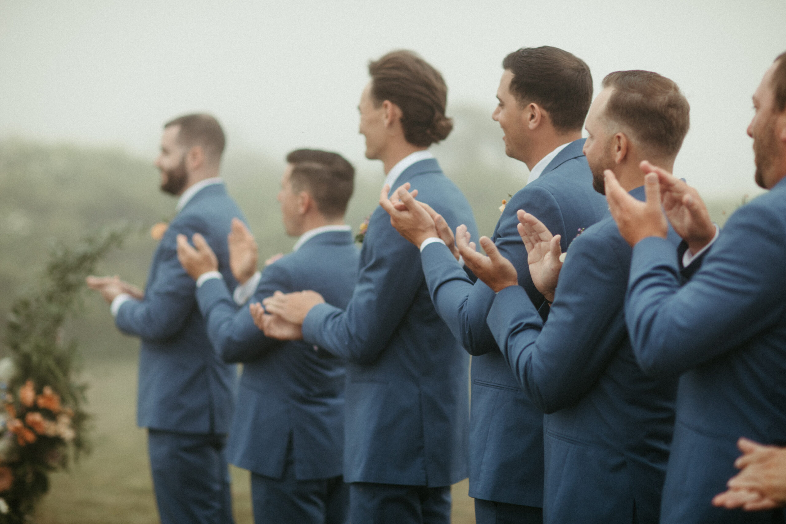 Groomemen clap for the newly wed couple.