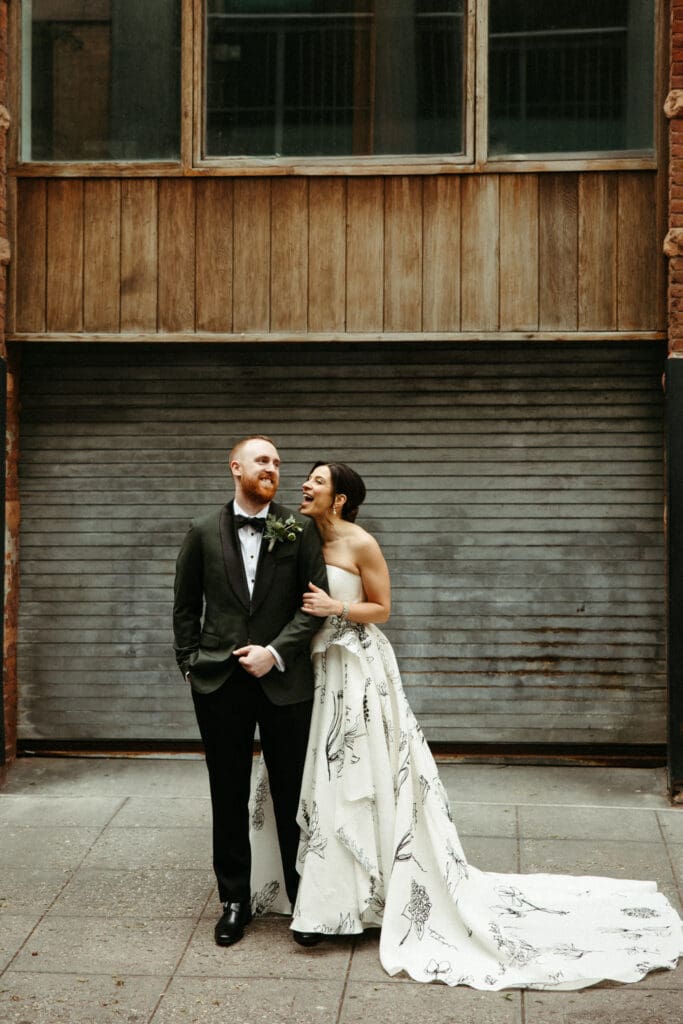 Bride and groom posing in front of a textured metal door outside Houston Hall in New York City