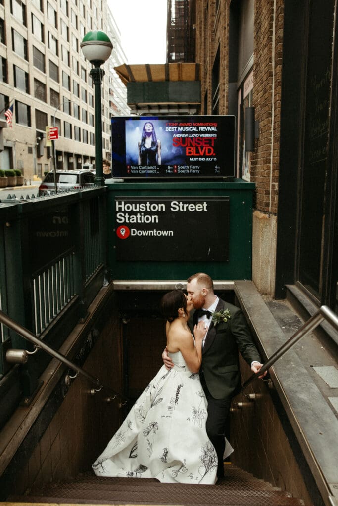 Bride and groom kissing on the stairs of the Houston Street subway station in New York City