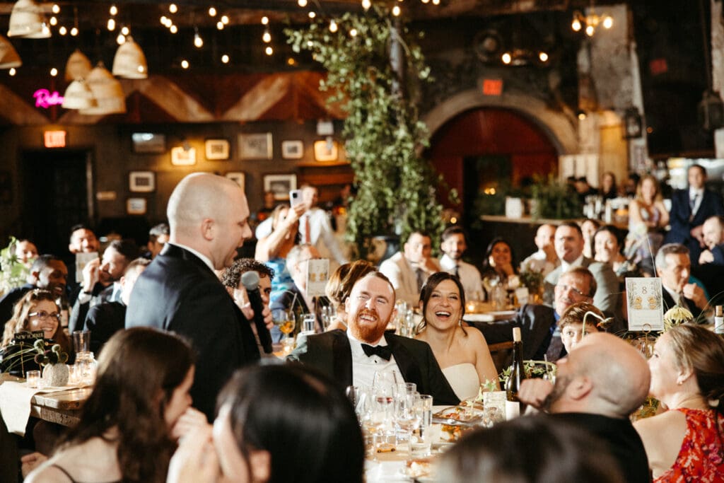 Wedding guests laugh during a heartfelt toast at Adrianna and Jack’s Houston Hall reception in New York City.
