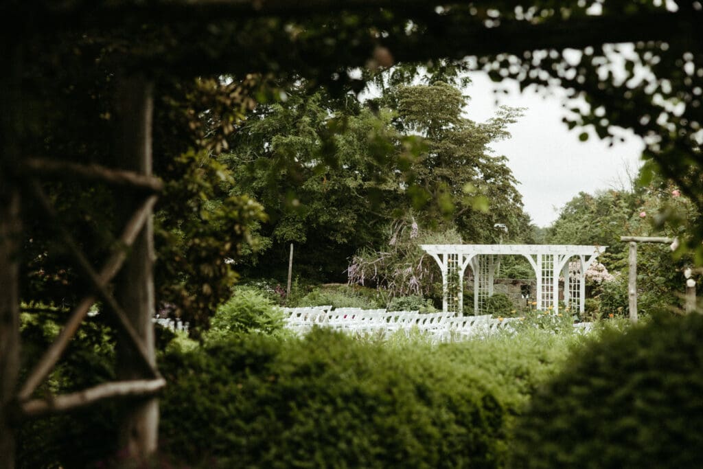 Wedding ceremony framed by trees and garden hedges at Stone Acres Farm, showing the natural landscape of a Stone Acres Farm wedding